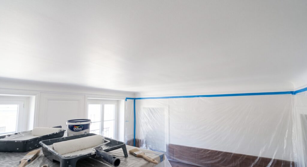 Plafond blanc et matériel de peinture dans une pièce protégée
