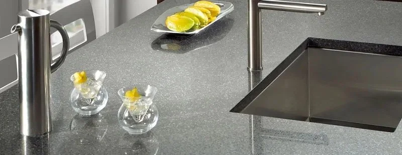 Plan de travail gris avec évier encastré, robinet et rondelles de citron