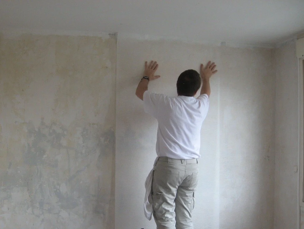 Pose d’un revêtement mural dans une pièce aux murs en préparation