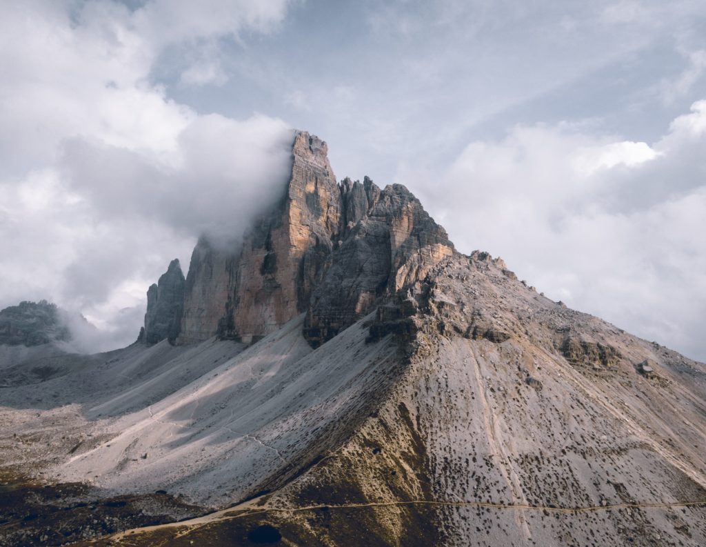 Sommets rocheux et versant pierreux sous les nuages